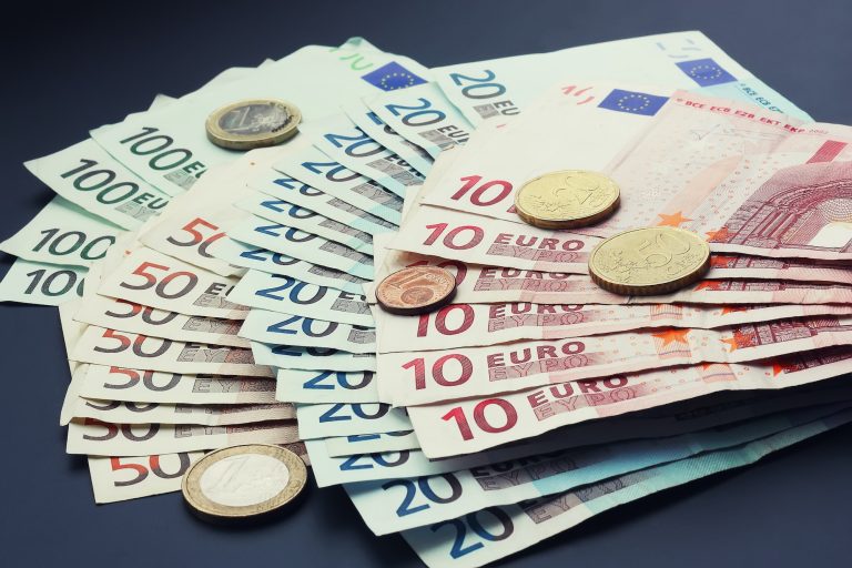 Verschiedene Euroscheine und Euromünzen aufeinander